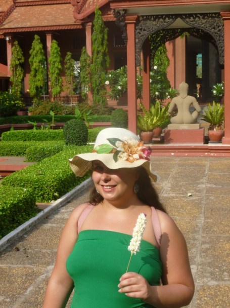 Minä kukkatikun kanssa Phnom Penhin kansallismuseon sisäpihalla. Tuollaisia kukkakeppejä sai viedä Buddhan patsailla museossa ja sain kukkatikun itselleni vielä lahjaksi kun annoin vähän rahaa museon hyväksi. 