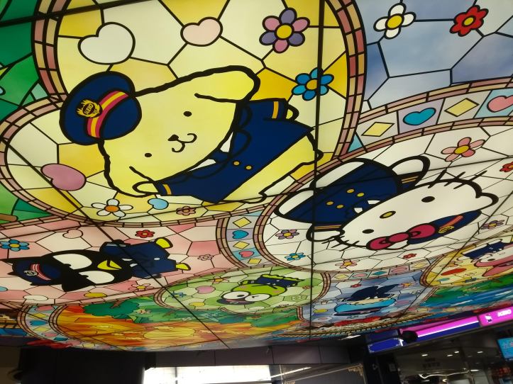 Pompompurin, Badtz-Maru ja Hello Kitty kattomaalauksessa Odakyu-Tama Center Stationilla
