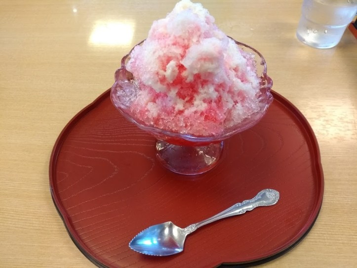 Mansikka-kakigōrini. Annos piti ensiksi valita ja maksaa automaatista, ja sitten se tuotiin kahvilan pöytään. 